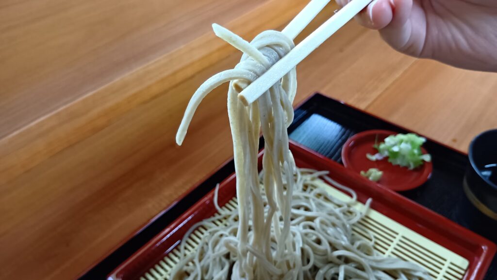 そば処 吉田の里の赤そば もりを箸で持ち上げた様子